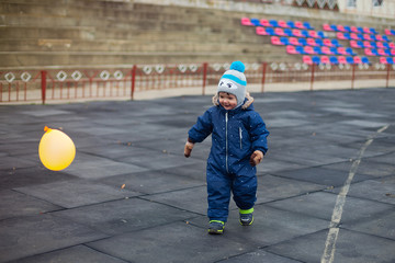 baby playing with a ball in the fresh air. walk, active lifestyle, sports. winter.