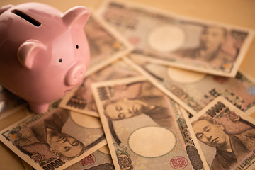 豚の貯金箱とお金のイメージ © aijiro