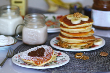 Breakfast pancakes served with honey and fruits and milk