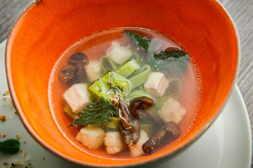 closeup delicious noodle soup with mushrooms and nettle leaves