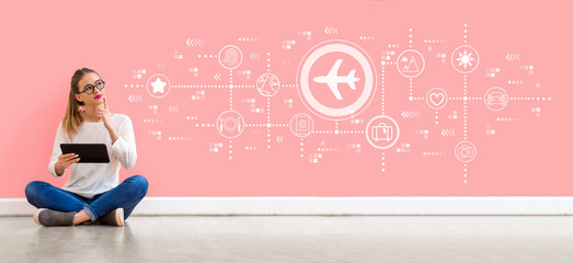 Airplane travel theme with young woman holding a tablet computer