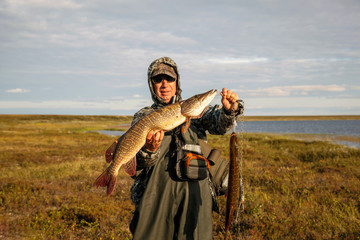 The fisherman caught a big pike,