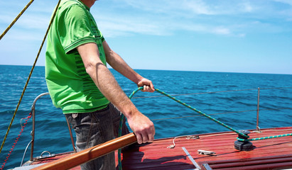 Man driving sailing yacht.