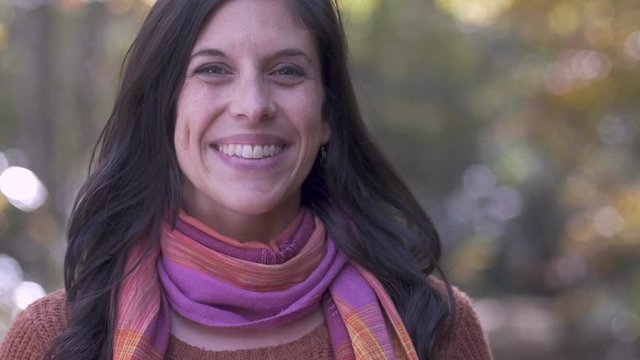 Portrait of a beautiful attractive brunette young woman wearing a scarf outside