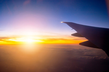 Silhouette of Airplane wing view out of the window the cloudy sunset sky background, Travel and Holiday vacation concept