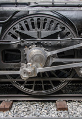 Detail of steam locomotive wheel on tracks.