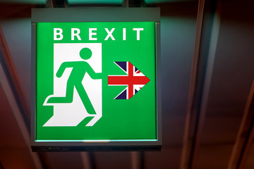The emergency exit sign shows the direction of escape in case leave European Union. The board indicate way for Brexit.