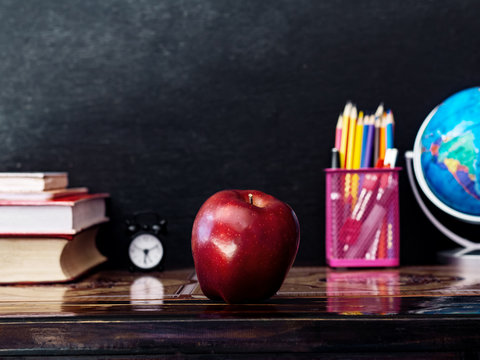 Education or back to school concept. apple and book and supplies on table