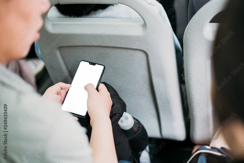 Poster The tourist relaxing while using smartphone in the bus blank screen for graphics display montage . Over the shoulder view of