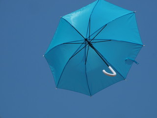 A foldable umbrella rises into blue sky