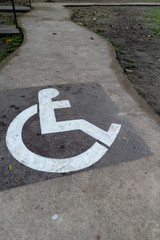 A sign of handicapped painted on the pathway.