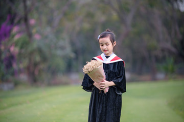 Asian cute child girl graduate. Girl smile on graduation kindergarten uniform