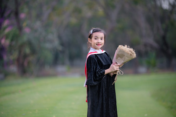 Asian cute child girl graduate. Girl smile on graduation kindergarten uniform