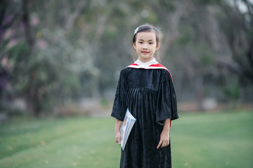 Asian cute child girl graduate. Girl smile on graduation kindergarten uniform