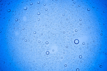 Rain droplets on blue glass background, Water drops on blue glass.