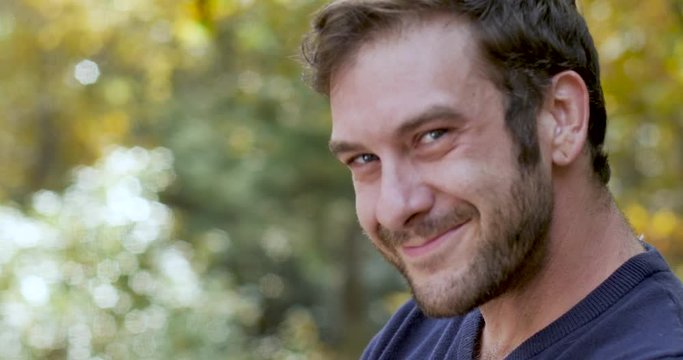 Man turns and looks at the camera with a goofy mischievous smile