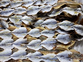 Top view of dried salted fish for cooking, for sale in the fish market, as a background (Yellow-stripe scad, Yellow-stripe trevally, Thinscaled trevally,Selaroides leptolepis)