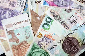 Fototapeta na wymiar Different countries money background close up. Belarusian rubles, Georgian lari, Polish zloty, Israeli shekels, Vietnamese dongs
