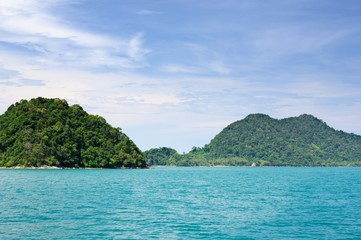Obraz na płótnie Canvas Landscape with turquoise tropical sea, dark blue sky with white clouds and tropical Koh Chang island on horizon in Thailand