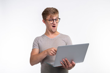 Emotions, education and people concept - a young handsome man looking in laptop and laughing
