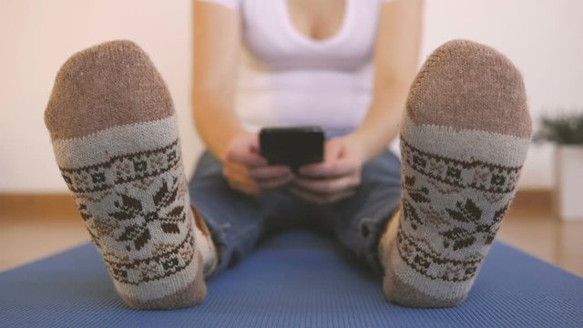 Woman in woolen knit sitting on a carimate uses a smartphone