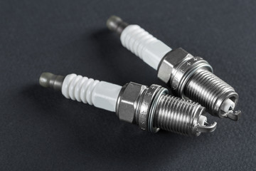 Two spark plugs on black background