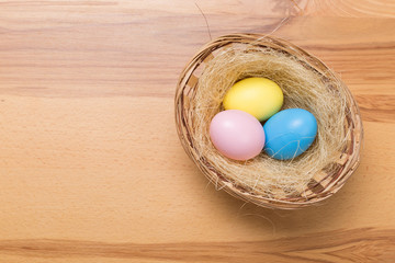 Easter eggs in the basket on wooden background