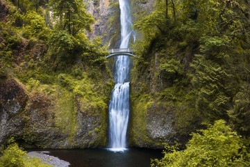 A waterfall with a bridge in deep forest cascades is located in the Columbia River Gorge in Oregon Beautifull waterfall background concept