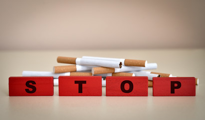 Red wooden blocks with word stop and cigarettes. Stop smoking concept. Selective focus.