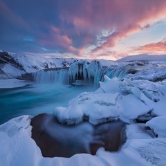 Godafoss waterfall at sunset - Views around Iceland, Northern Europe in winter with snow and ice. One of the most powerful waterfalls in Europe. Beautiful winter landscape concept background