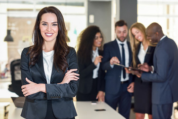 Businesswoman leader in modern office with businesspeople working at background