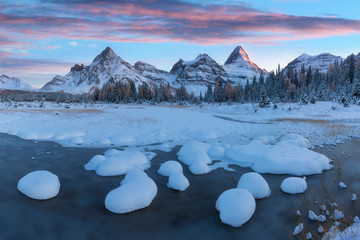 Winter sunset. Mount Assiniboine, also known as Assiniboine Mountain, is a pyramidal peak mountain located on the Great Divide, on the British Columbia/Alberta border in Canada. 