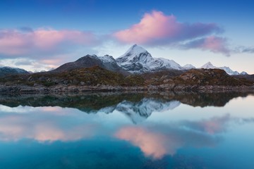 Sunset or sunrise panoramic view on stunning mountains in Lofoten islands with first snow, Norway, Mountain coast landscape, Arctic circle. Concept. Amazing Nature background