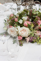 The restaurant is decorated with flowers on the wedding day. Candelabra with candles on the table.