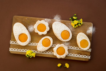 Cookies in the shape of white eggs with apricot yolk as homemade decoration