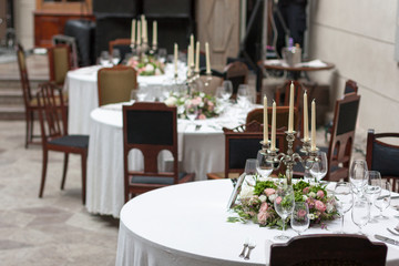 The restaurant is decorated with flowers on the wedding day. Candelabra with candles on the table.