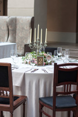 Beautiful flowers on the table.The restaurant is decorated with flowers on the wedding day. Candelabra with candles on the table.  Number two on the table