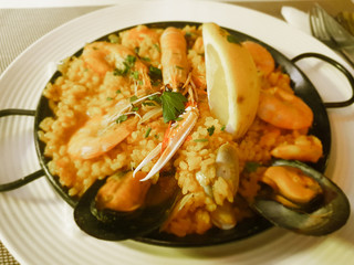 Traditional Spanish paella with seafood and chicken. Served in a metal pan.