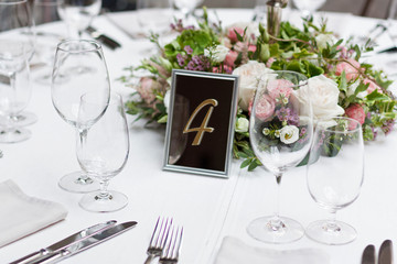 Beautiful flowers on the table.The restaurant is decorated with flowers on the wedding day. Candelabra with candles on the table.  Number four.