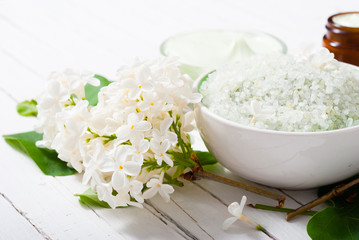 cosmetic creams and white lilac blossom on bright wooden table background