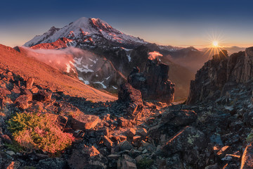 Morning light high above the cloud layer on Mount Rainier. Beautiful Paradise area, Washington state, USA in the fall with snow on Mount Rainier on a sunny day and morning with blue sky. Cascade Range