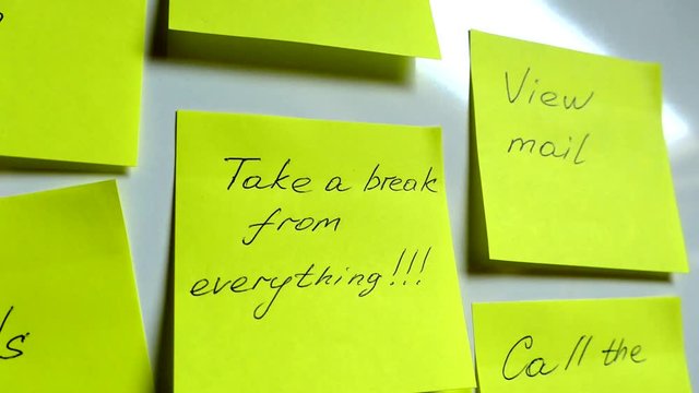 Self-adhesive notes on a white board. Rest from everything. List of tasks for work. A lot of work and tasks.