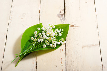 bouquet of lily of the valley flowers on old painted bright wood table background