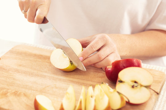 Woman Cuts An Apple Into Slices With A Knife, Close-up