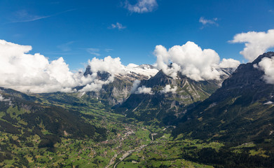Helicopter walk over the Swiss Alps in the town of Interlaken. View of the valley, alpine mountains and cloudy sky. Switzerland