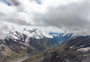 Helicopter walk over the Swiss Alps in the town of Interlaken. View of the valley, alpine mountains and cloudy sky. Switzerland