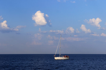 Yacht with people in the Black sea, silence, sky in the clouds