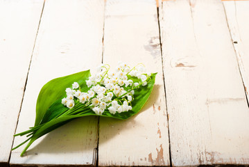 bouquet of lily of the valley flowers on old painted bright wood table background