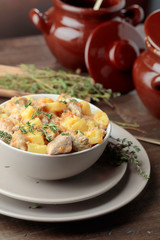  Meat stewed with potatoes, carrots and spices in ceramic pot on wooden background.