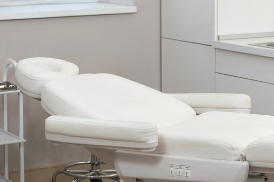 Interior of a cosmetology office, close-up on chair. Modern white chair for cosmetology procedure